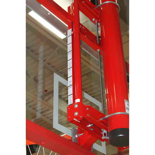 Gared basketball backboard with red support frame and height adjustment mechanism in indoor gym
