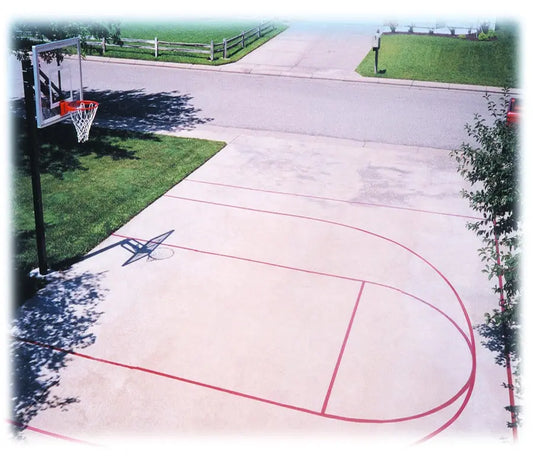 Outdoor basketball court with First Team FT20 basketball hoop mounted on black pole on driveway
