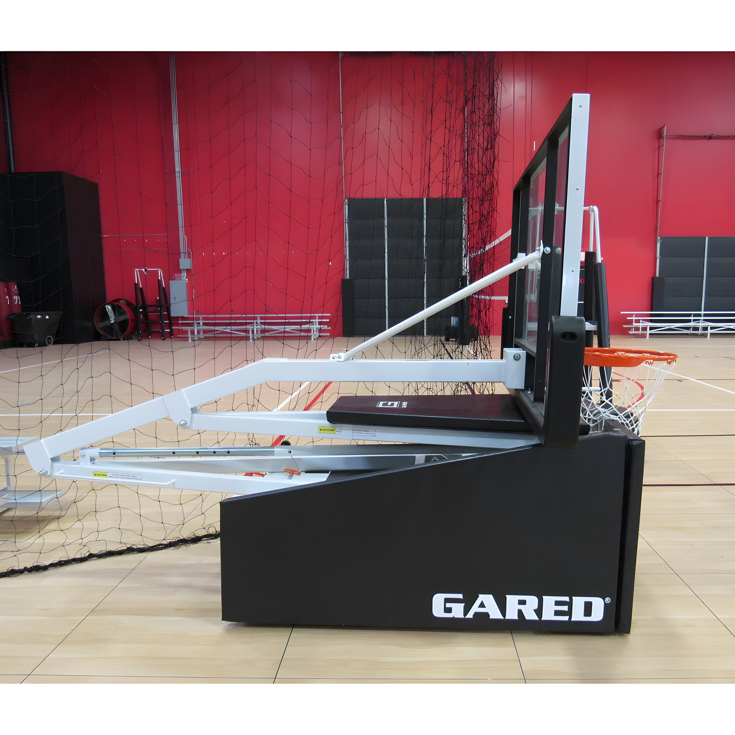 Gared basketball hoop system with adjustable support arms and black base on indoor court