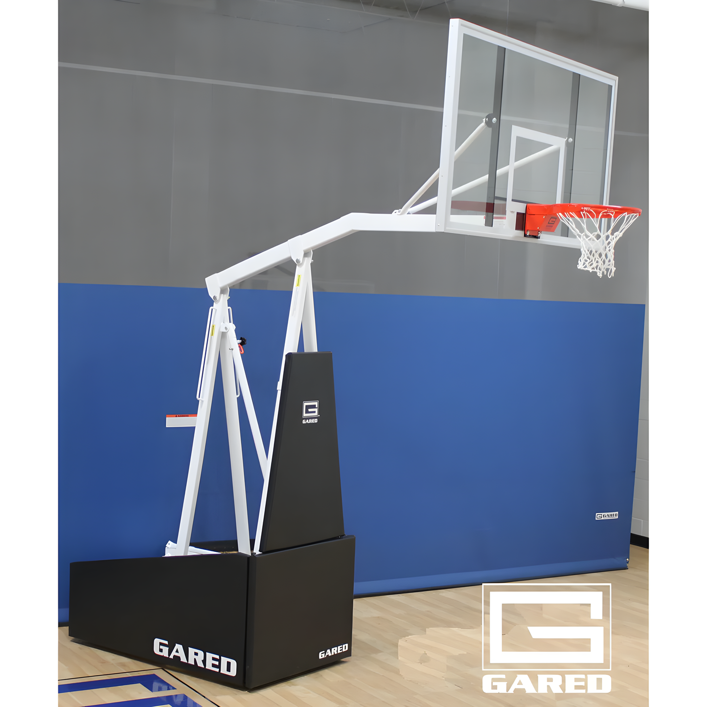 Gared portable basketball hoop with clear backboard and white frame on indoor gym floor