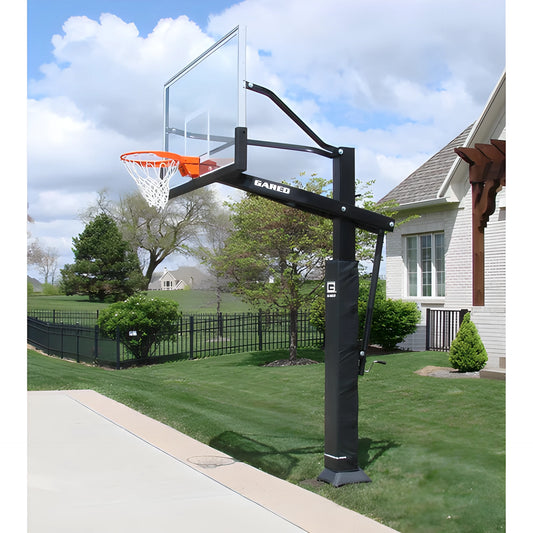 Gared in ground basketball hoop with clear backboard and orange rim installed on a residential lawn