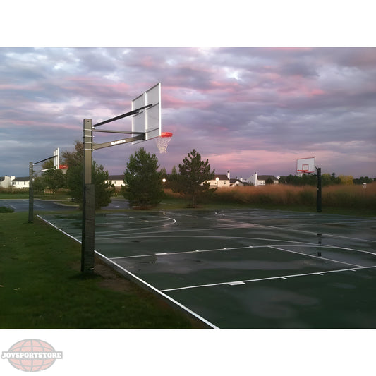 Gared outdoor basketball hoop installed on an outdoor court during sunset with cloudy sky