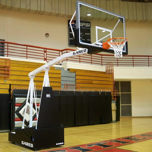 Gared portable basketball hoop with clear backboard and orange rim set up in indoor gym