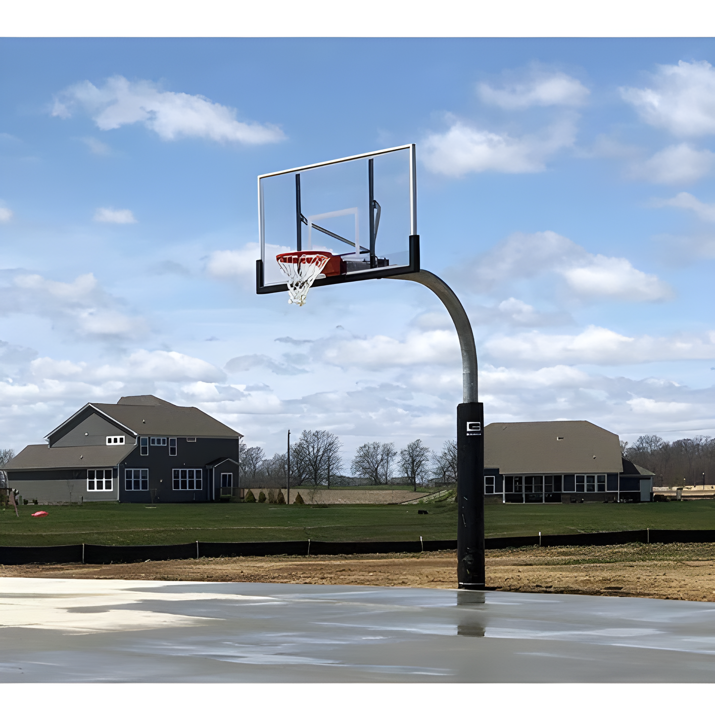 Gared outdoor basketball hoop with clear backboard and red rim installed on concrete court