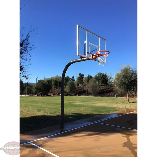 Gared outdoor basketball hoop with clear backboard and orange rim on outdoor court under blue sky