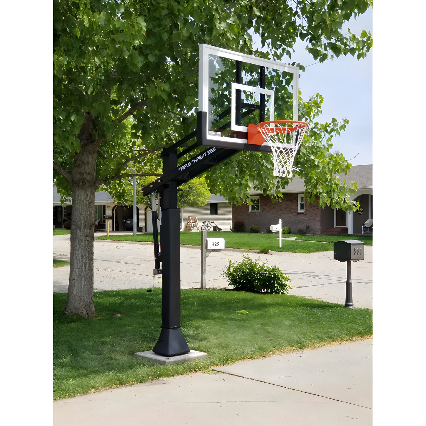 Ironclad In Ground Basketball Hoop with clear backboard and orange rim installed on residential driveway