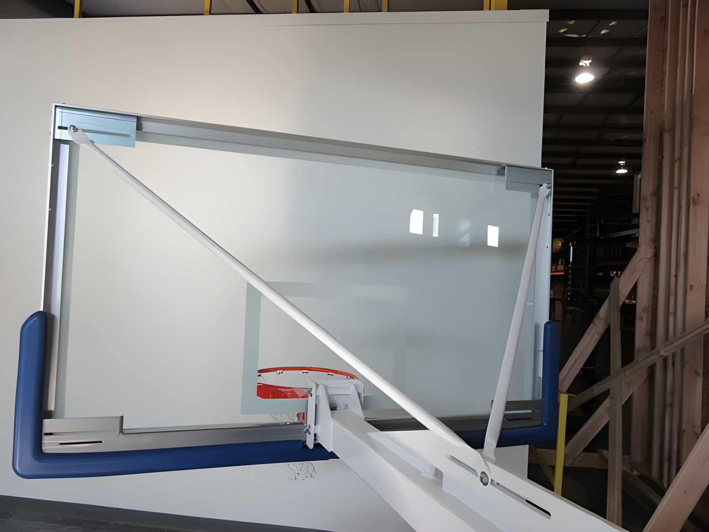 FIRST TEAM portable basketball hoop with clear backboard and red rim in indoor warehouse