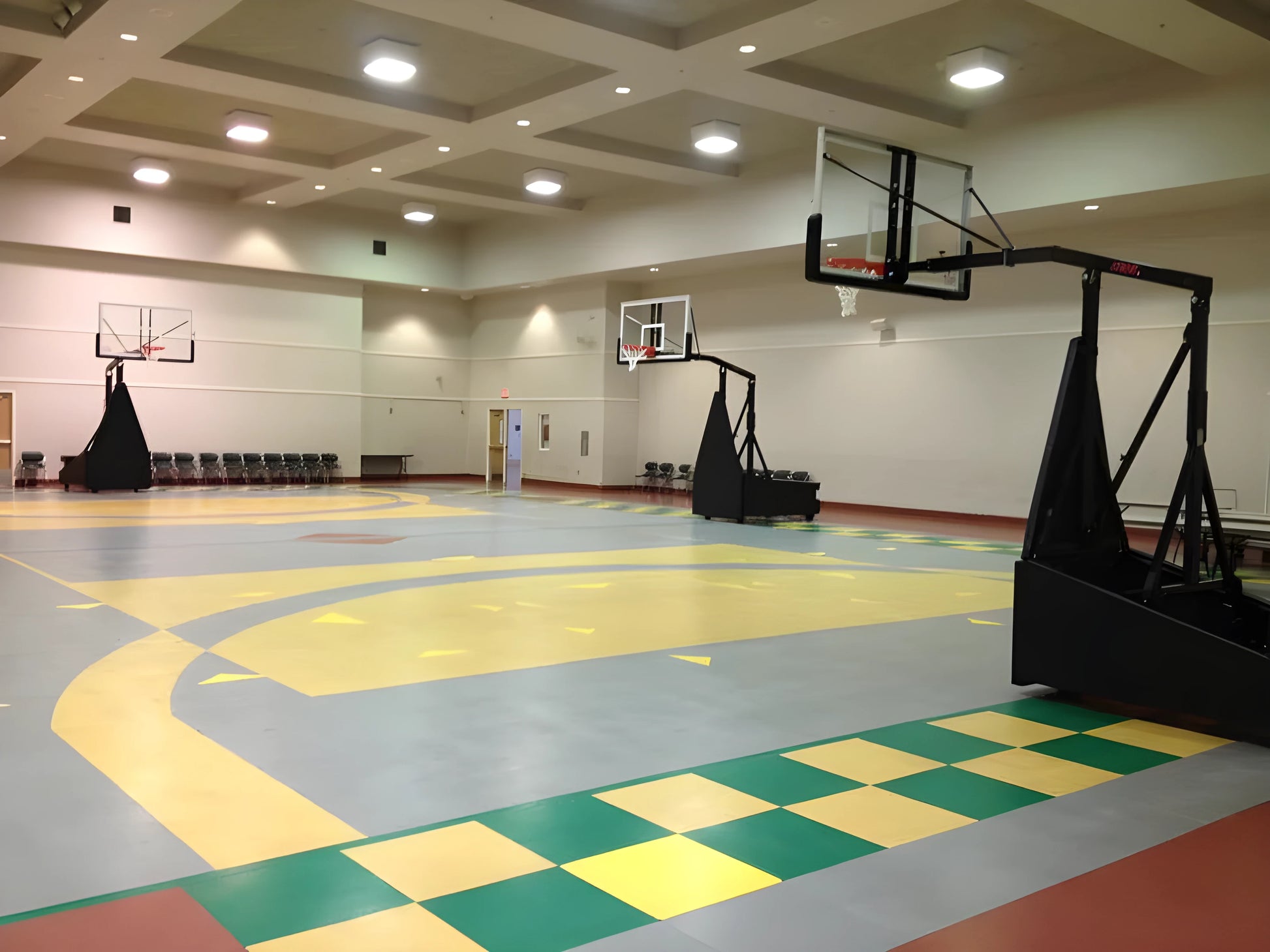 FIRST TEAM portable basketball hoop set up indoors on a gym court with multiple hoop visible