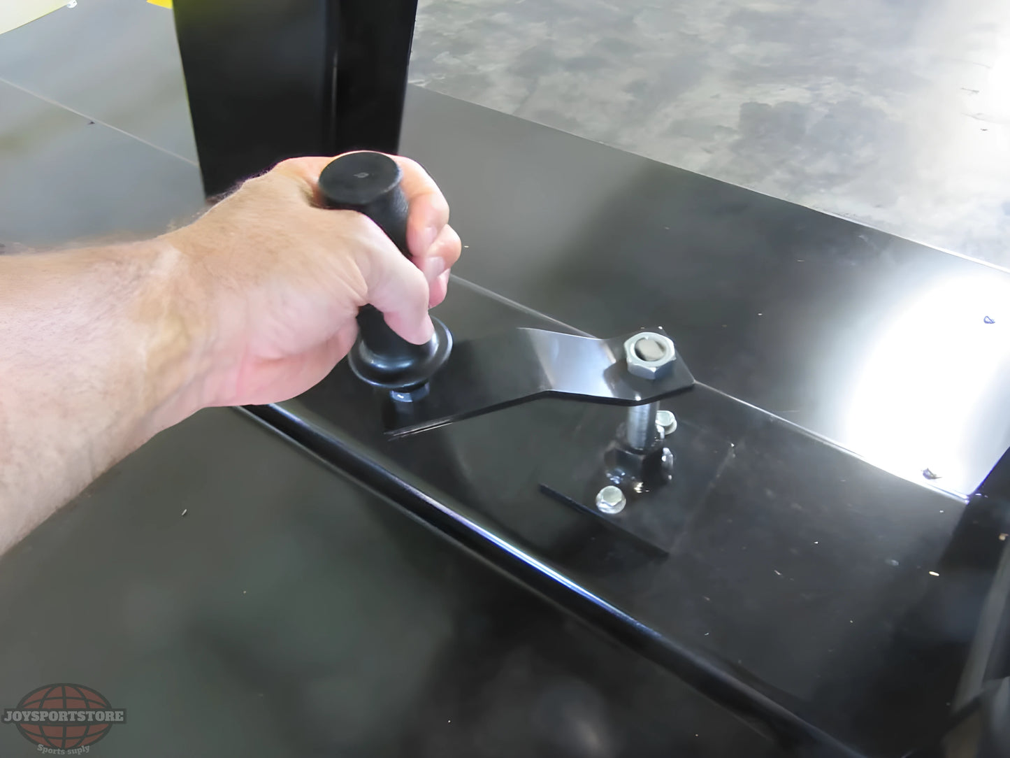 Hand adjusting the height mechanism on a FIRST TEAM portable basketball hoop base