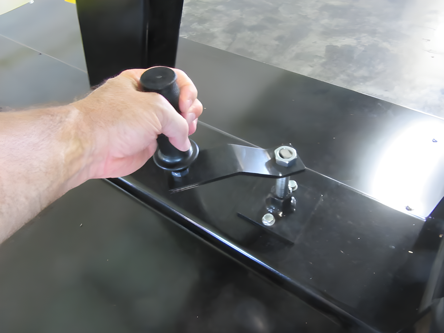 Hand adjusting the height mechanism on a FIRST TEAM portable basketball hoop