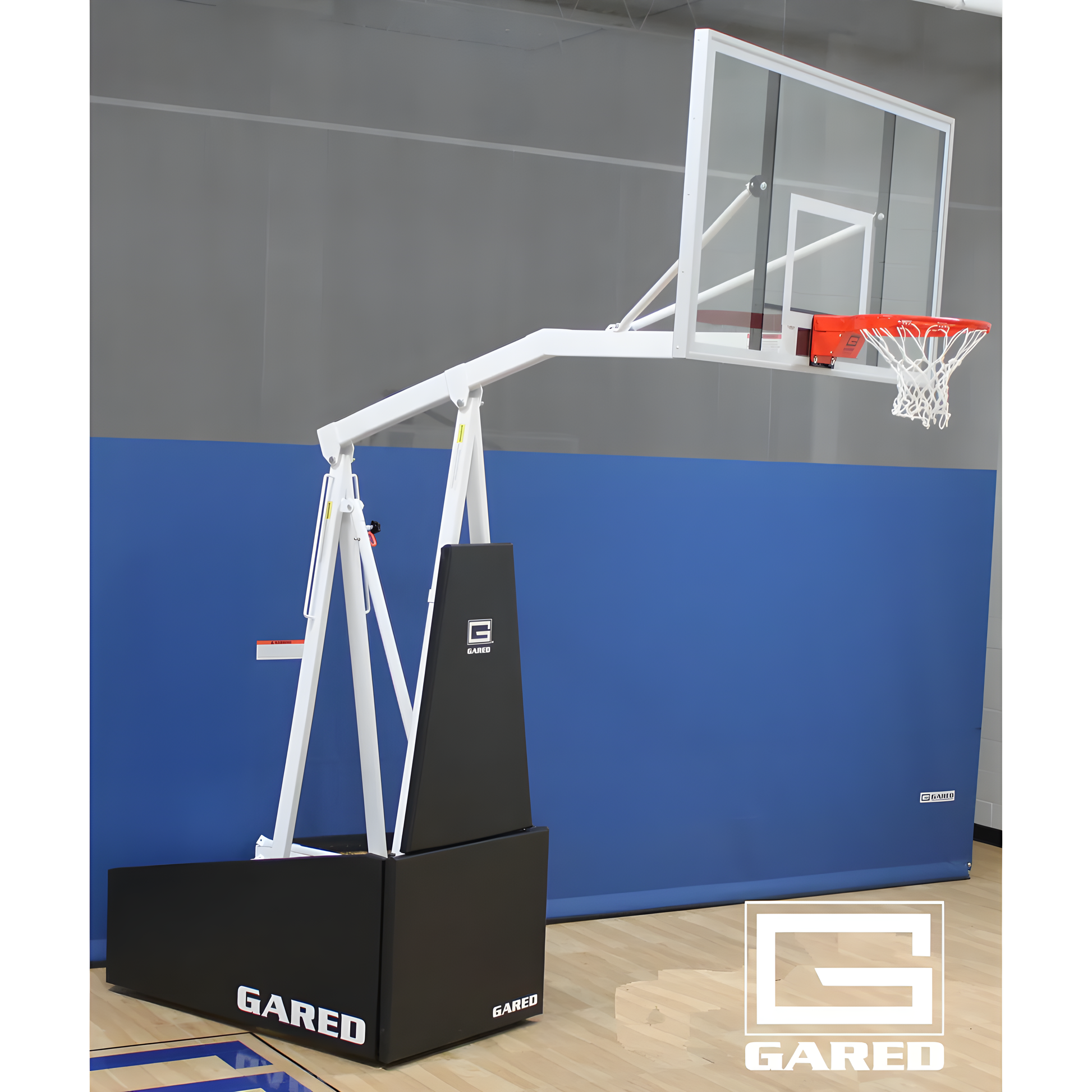Gared portable basketball hoop with clear backboard and white frame on indoor gym floor
