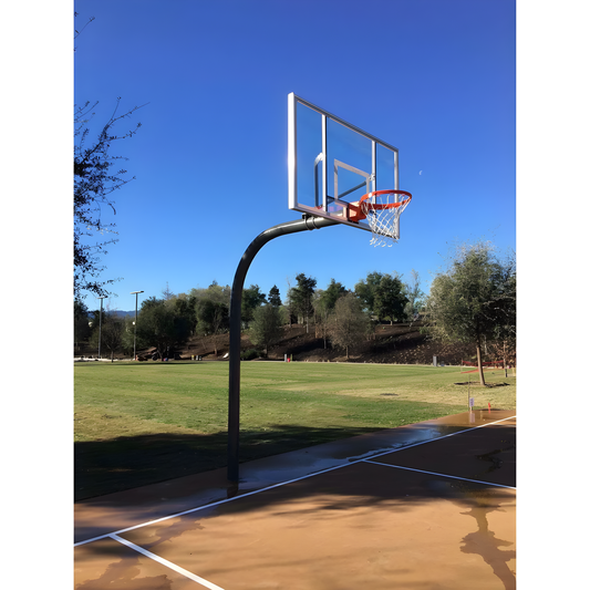 Gared outdoor basketball hoop with clear backboard and orange rim on outdoor court under blue sky