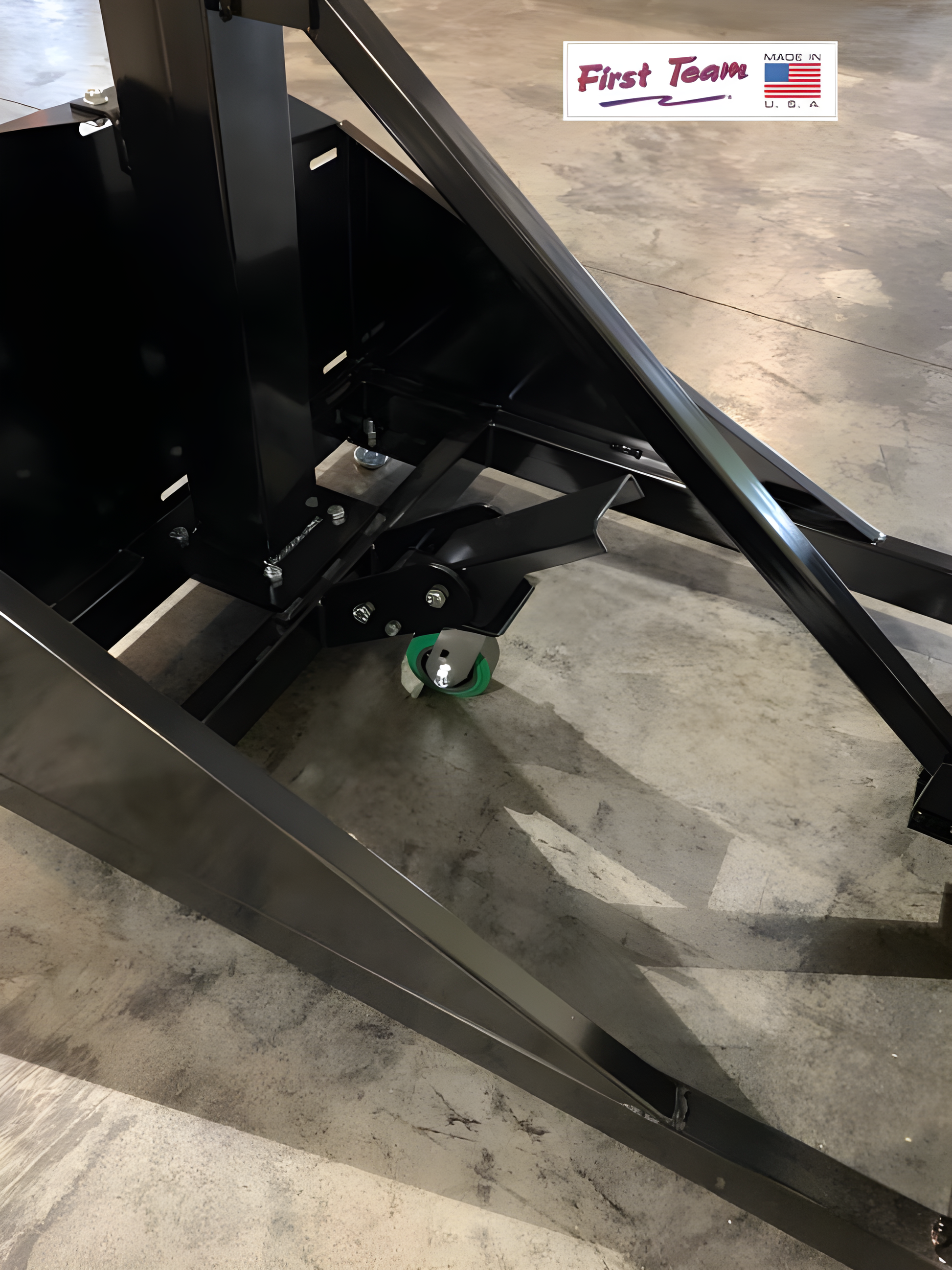 Close-up of FIRST TEAM portable basketball hoop base with support frame and wheel on concrete floor